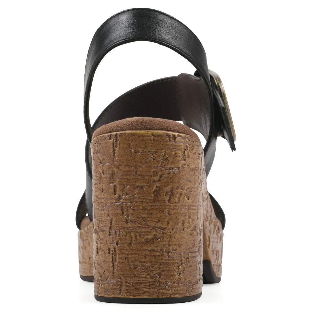 Rear view of a black platform sandal with ankle buckle and a brown, faux cork sole