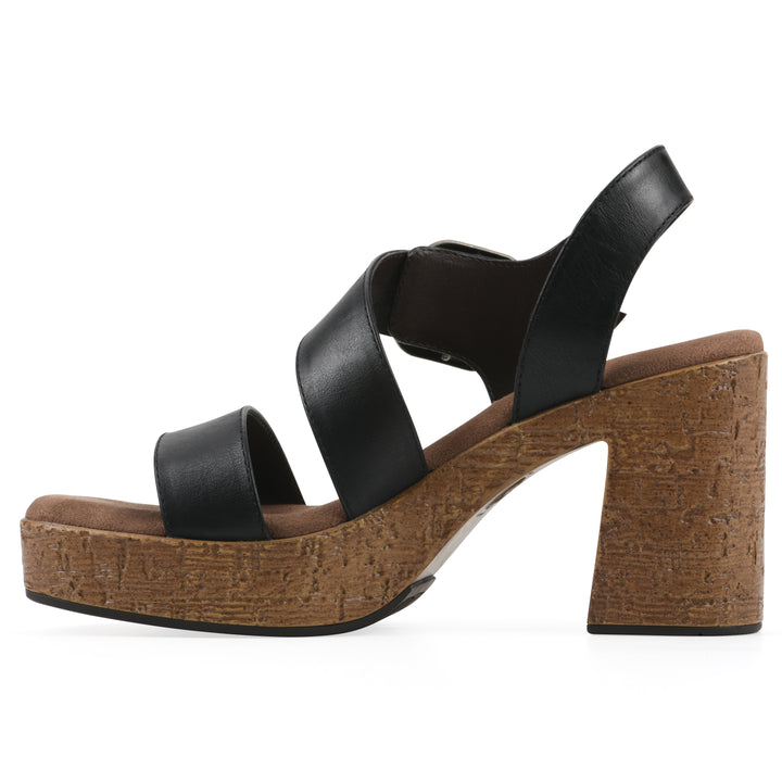 Side view of a black platform sandal with ankle buckle and a brown, faux cork sole