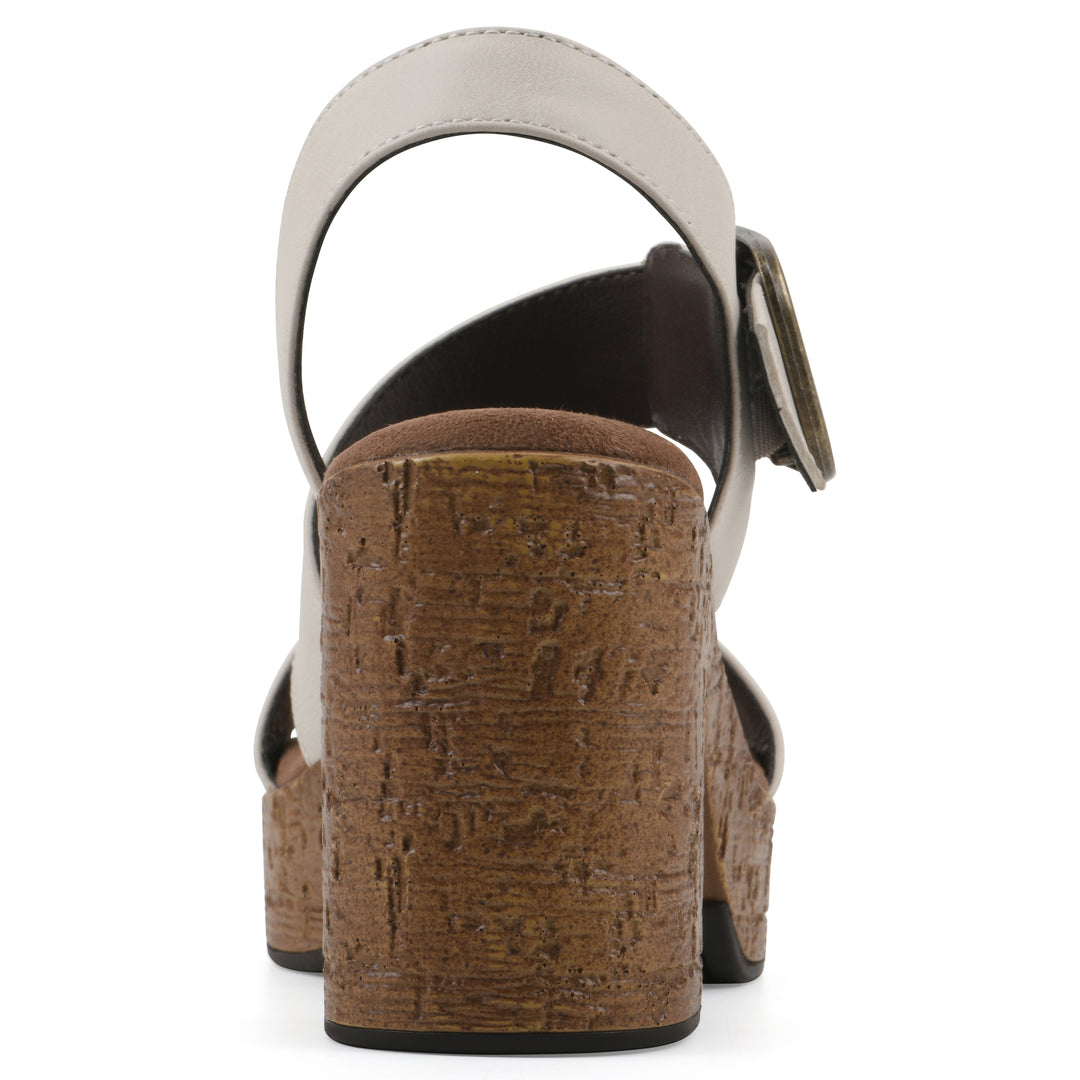 Rear view of a white platform sandal with ankle buckle and a brown, faux cork sole