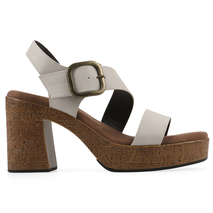 Side view of a white platform sandal with ankle buckle and a brown, faux cork sole