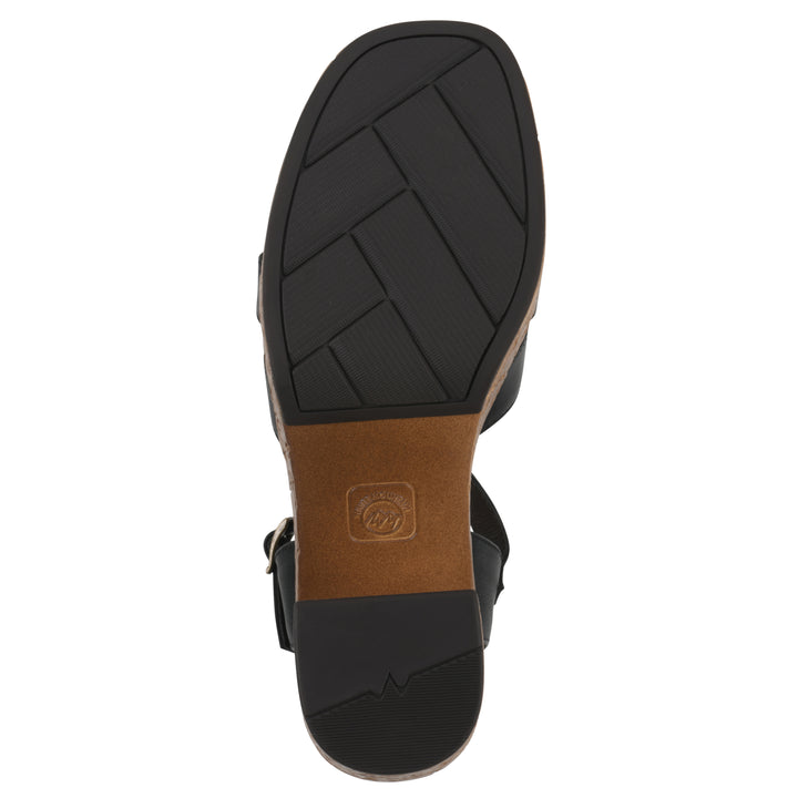 Sole view of a black faux leather platform sandal with buckle style ankle strap and a brown molded cork bottom