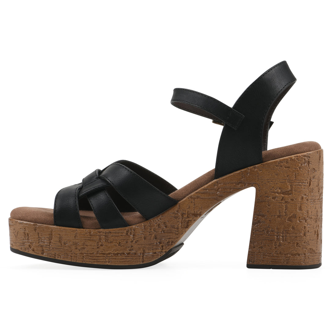 Side view of a black faux leather platform sandal with buckle style ankle strap and a brown molded cork sole