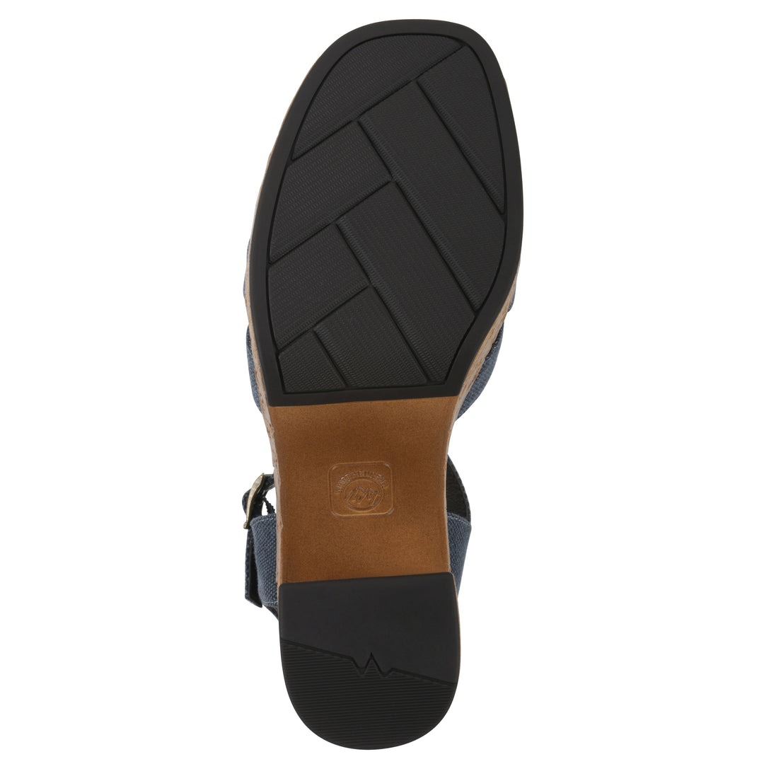Sole view of a denim blue fabric platform sandal with buckle style ankle strap and a brown molded cork bottom