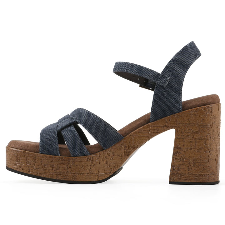Side view of a denim blue fabric platform sandal with buckle style ankle strap and a brown molded cork sole