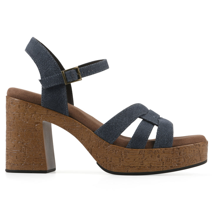 Side view of a denim blue fabric platform sandal with buckle style ankle strap and a brown molded cork sole