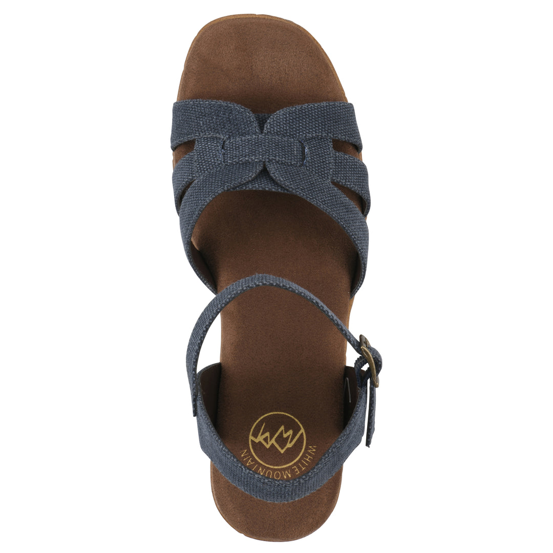 Top view of a denim blue fabric platform sandal with buckle style ankle strap and a brown molded cork sole