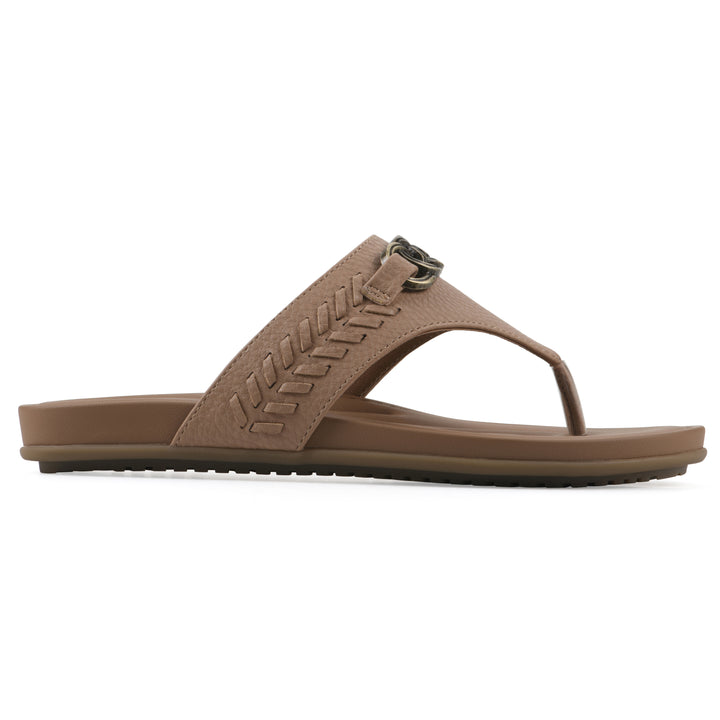 Side view of a tan thong sandal with metal embellishment and a brown sole