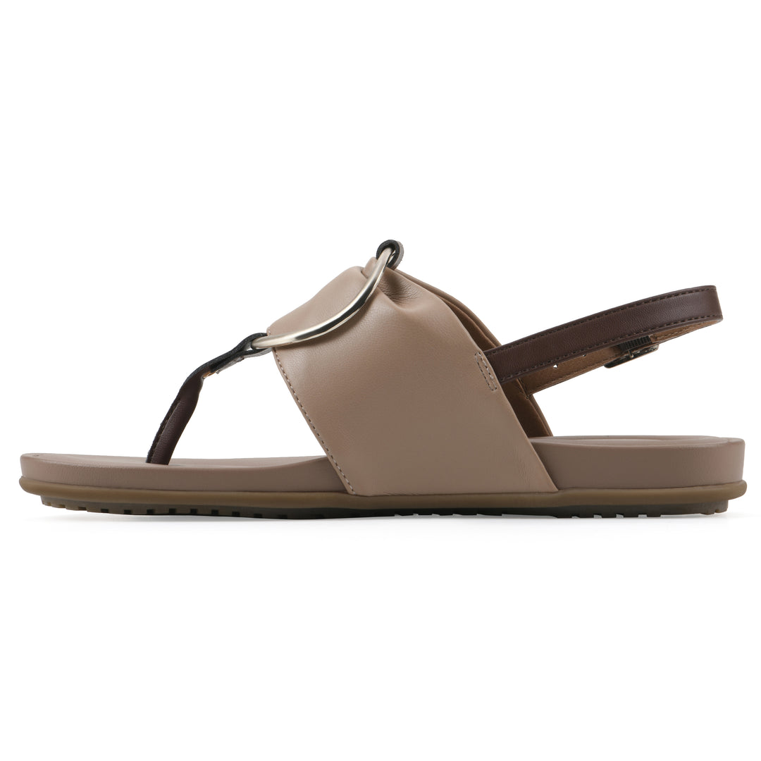 Side view of a tan thong sandal with a centered metallic ring, adjustable heel strap, and beige sole