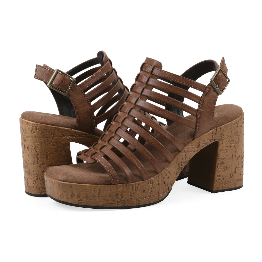 Angle view of a pair of brown gladiator platform sandals with adjustable ankle buckle and cork style heel