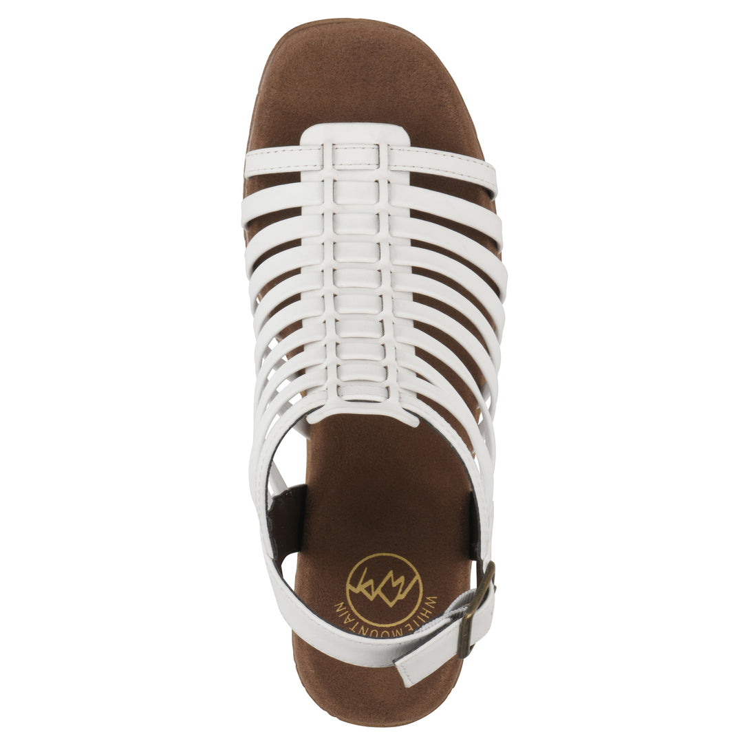 Top view of a white gladiator platform sandal with adjustable ankle buckle and cork style heel