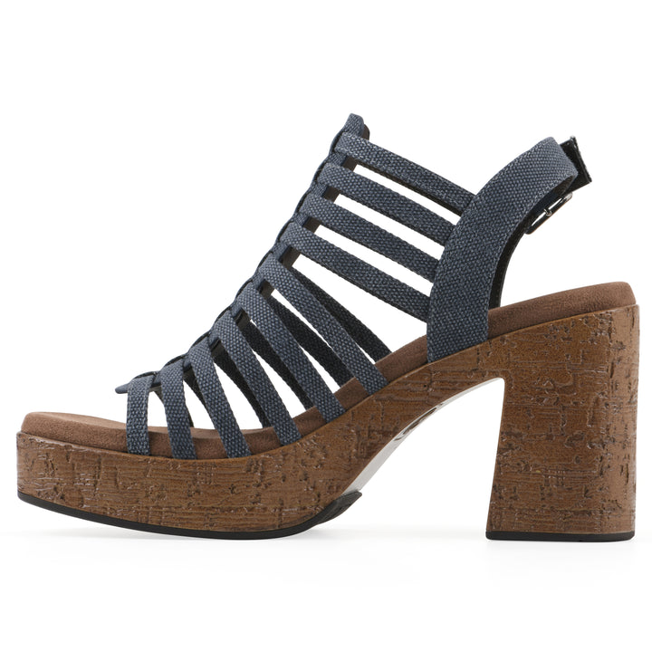 Side view of a denim gladiator platform sandal with adjustable ankle buckle and cork style heel