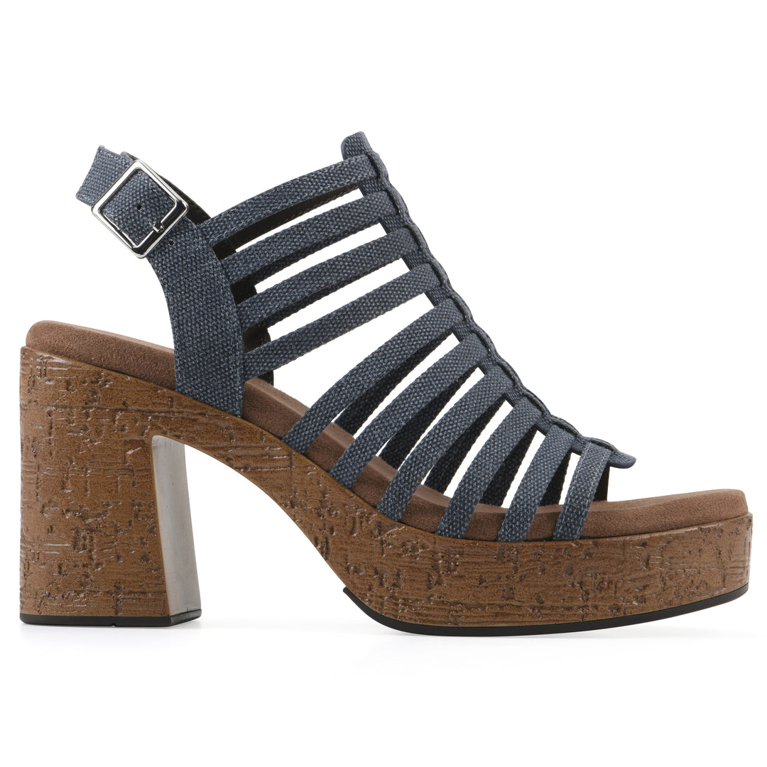 Side view of a denim gladiator platform sandal with adjustable ankle buckle and cork style heel