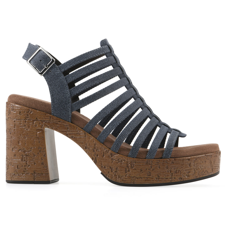 Side view of a denim gladiator platform sandal with adjustable ankle buckle and cork style heel