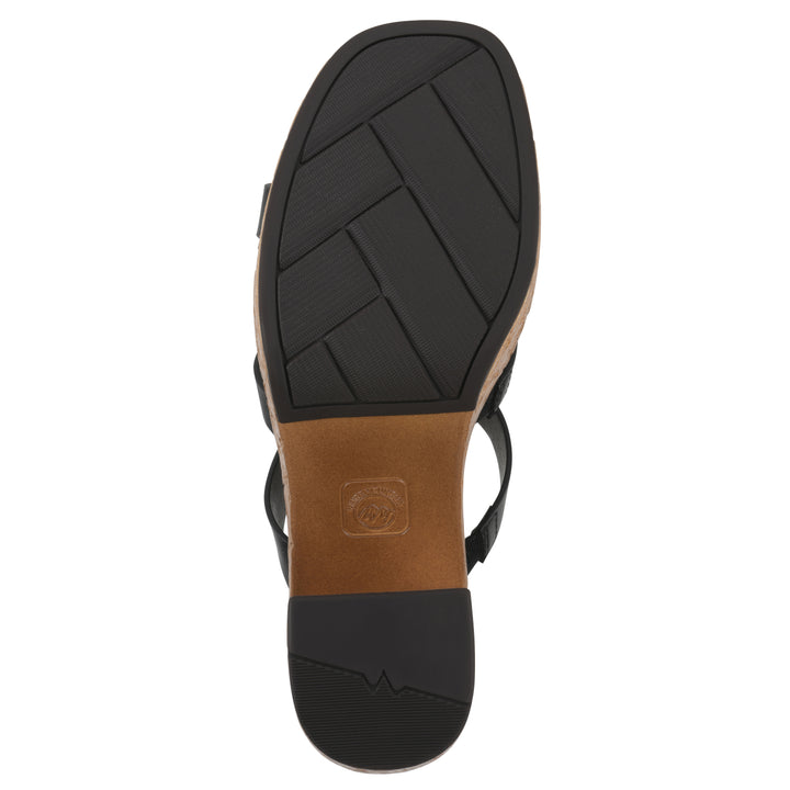 Sole view of a black faux leather platform sandal, with multi-interlaced straps and a brown cork style sole with black bottom