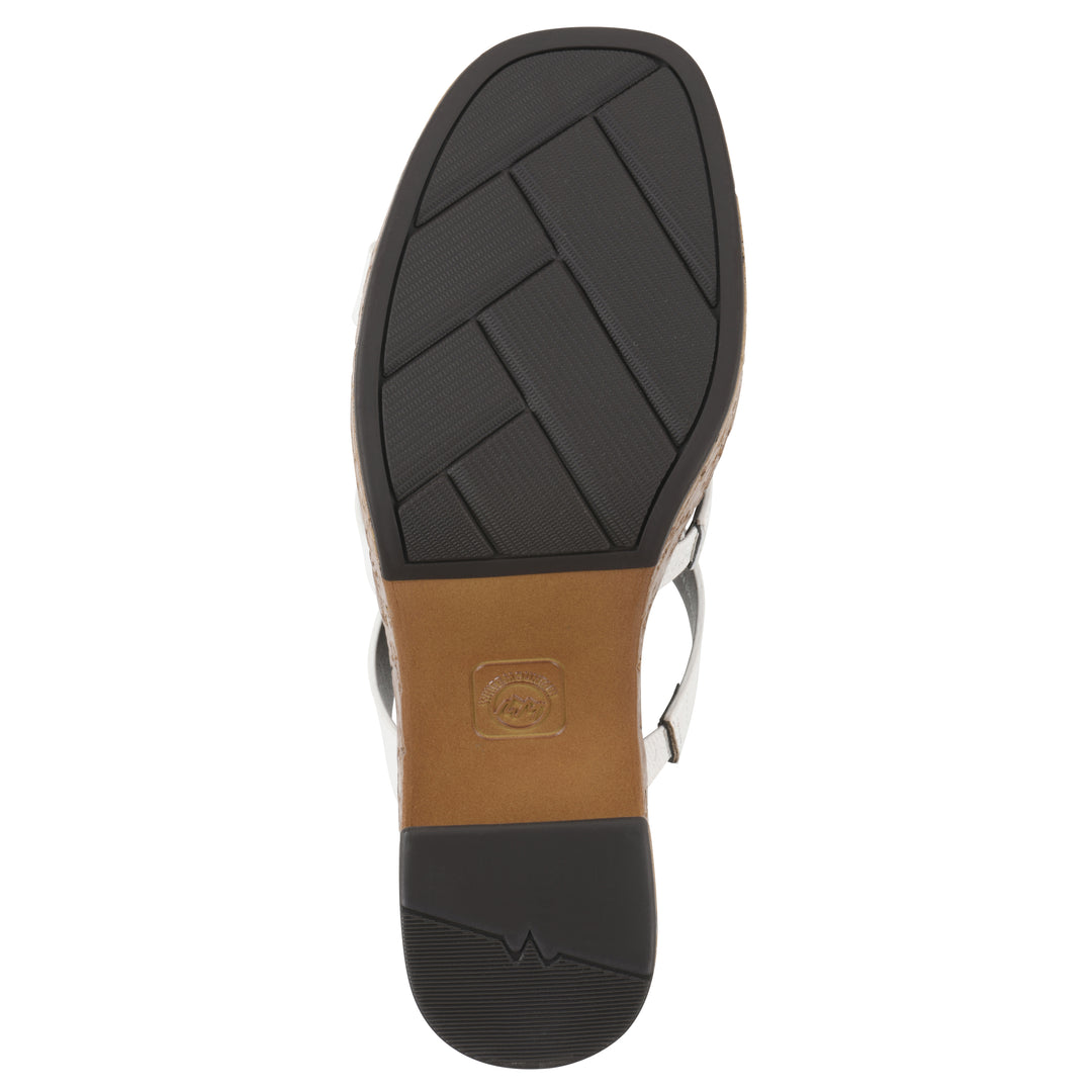 Sole view of a white faux leather platform sandal, with multi-interlaced straps and a brown cork style sole with black bottom